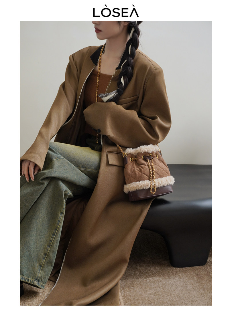 Model wearing a brown coat and carrying a quilted bucket bag