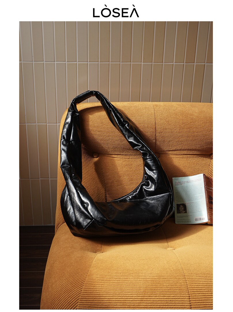 Black leather shoulder bag on a chair