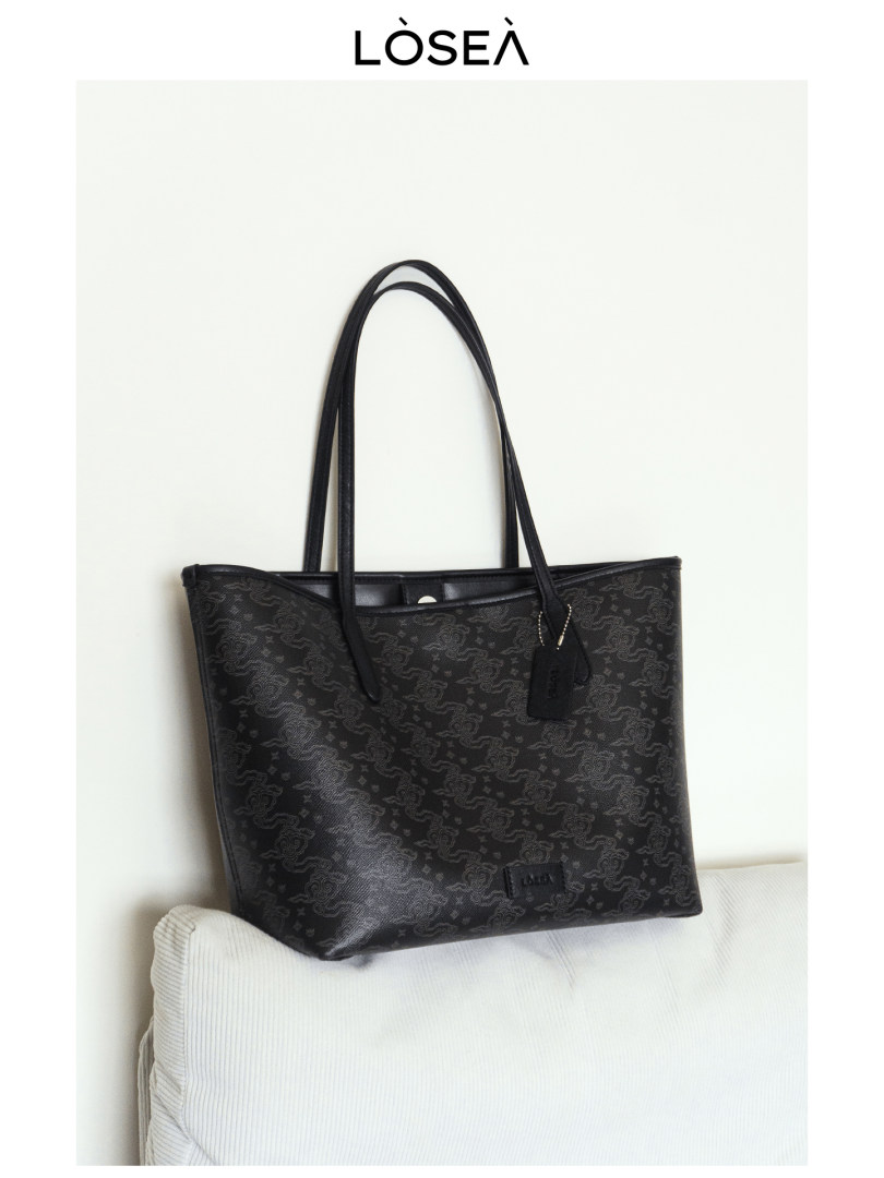 Black patterned tote bag with long handles on a white background