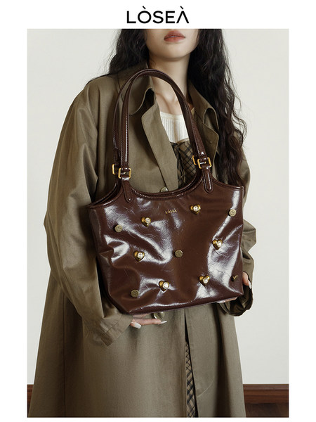 Brown leather shoulder handbag worn by a model