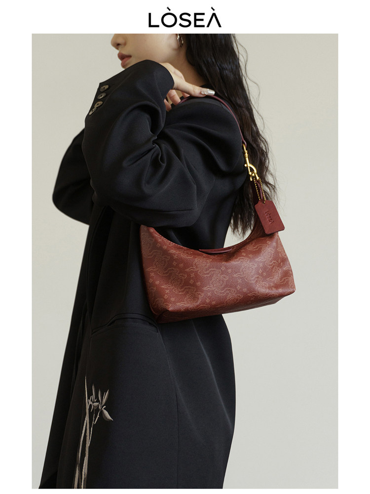 Red patterned shoulder handbag worn by a model