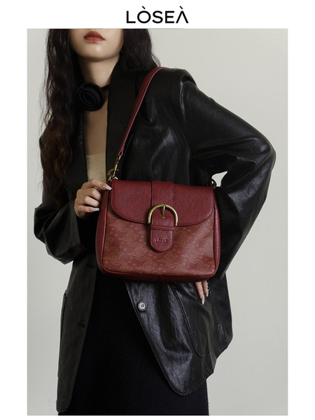 Red leather shoulder handbag worn by a model