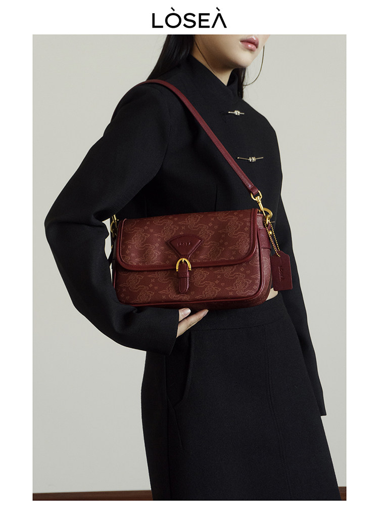 Red leather shoulder bag worn by a model