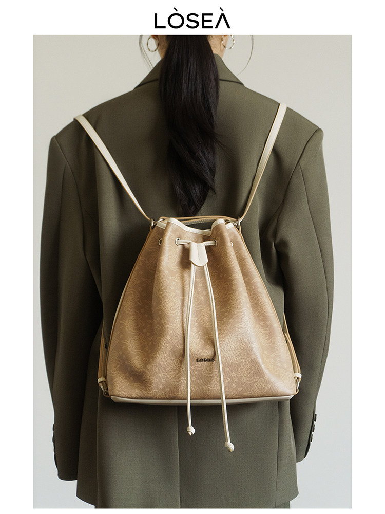 Beige drawstring backpack worn on a model's back