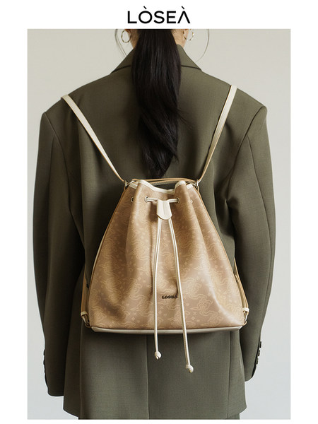 Beige drawstring backpack worn on a model's back