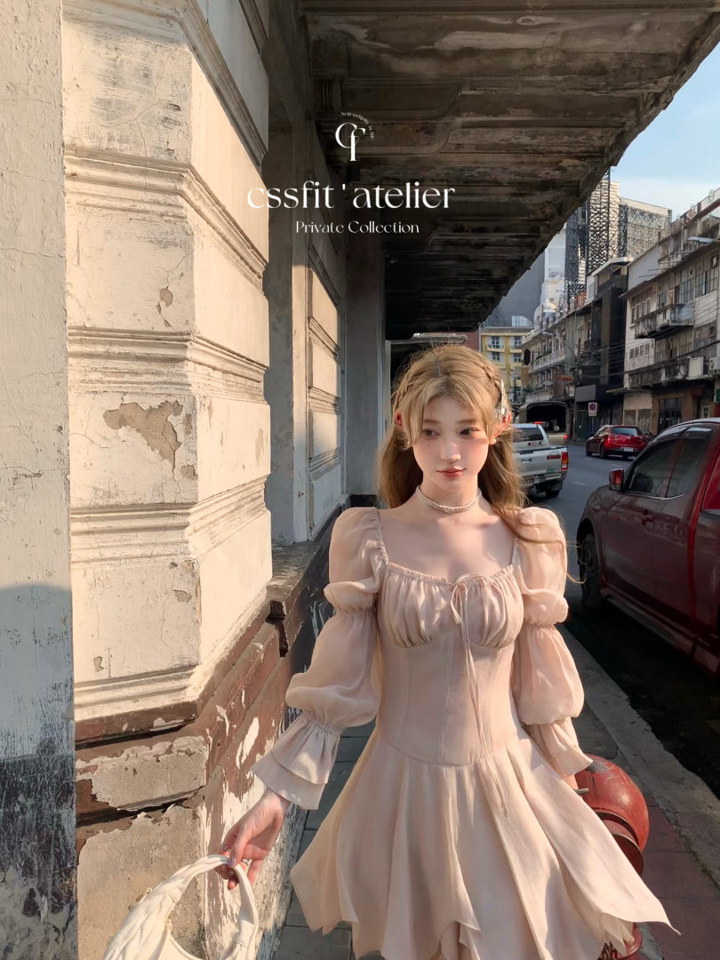 Woman wearing a light beige puff-sleeve dress on a city street