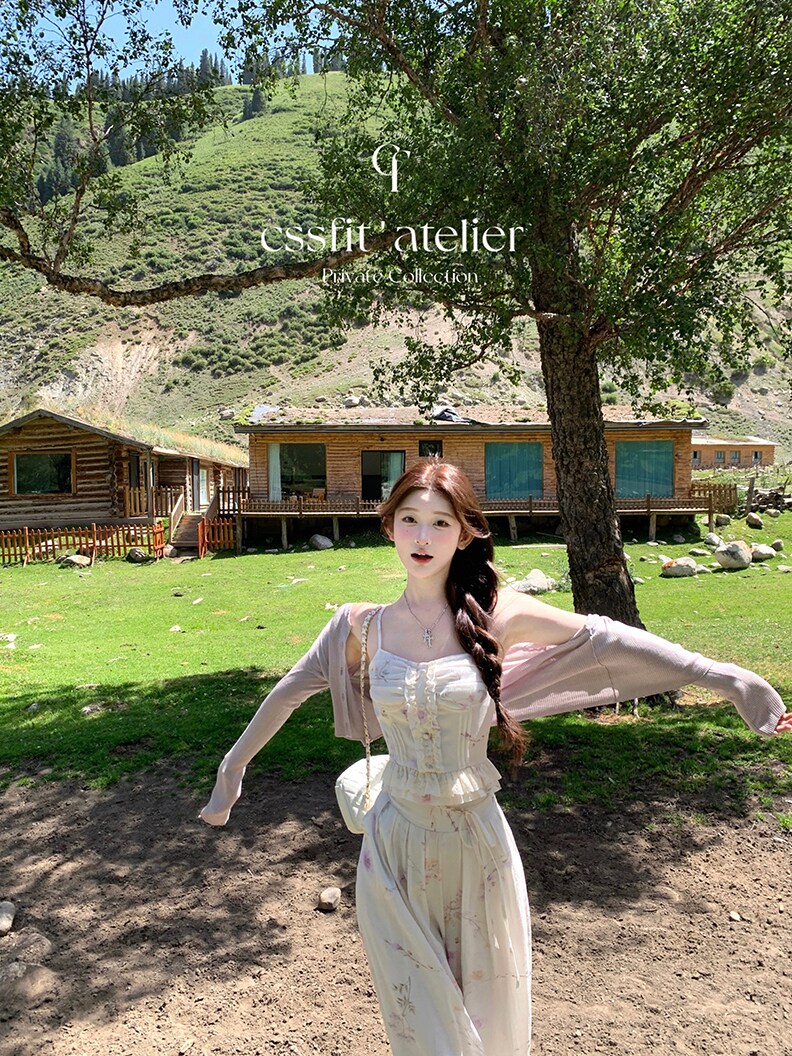 Woman wearing a light cream two-piece outfit outdoors in a scenic landscape