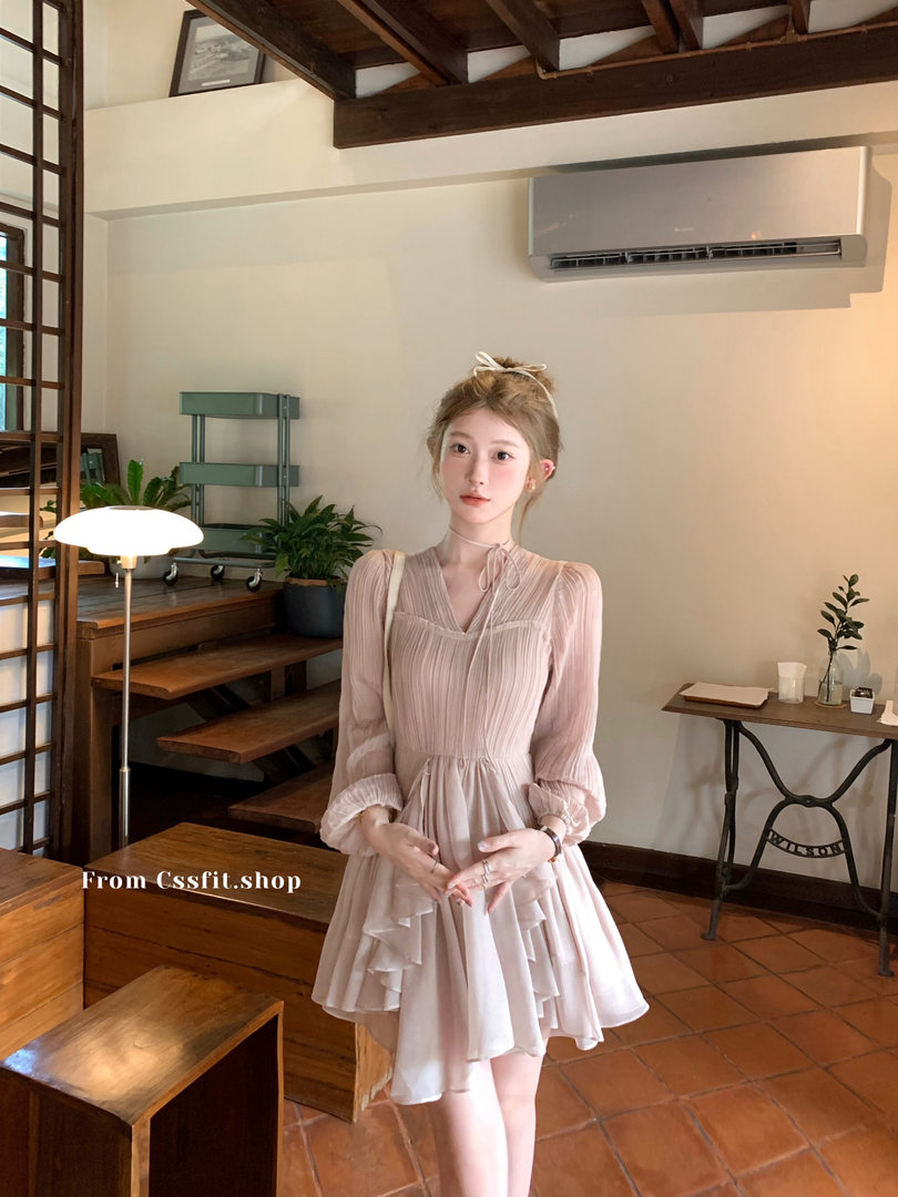 Model wearing a light pink sheer long-sleeve ruffle dress