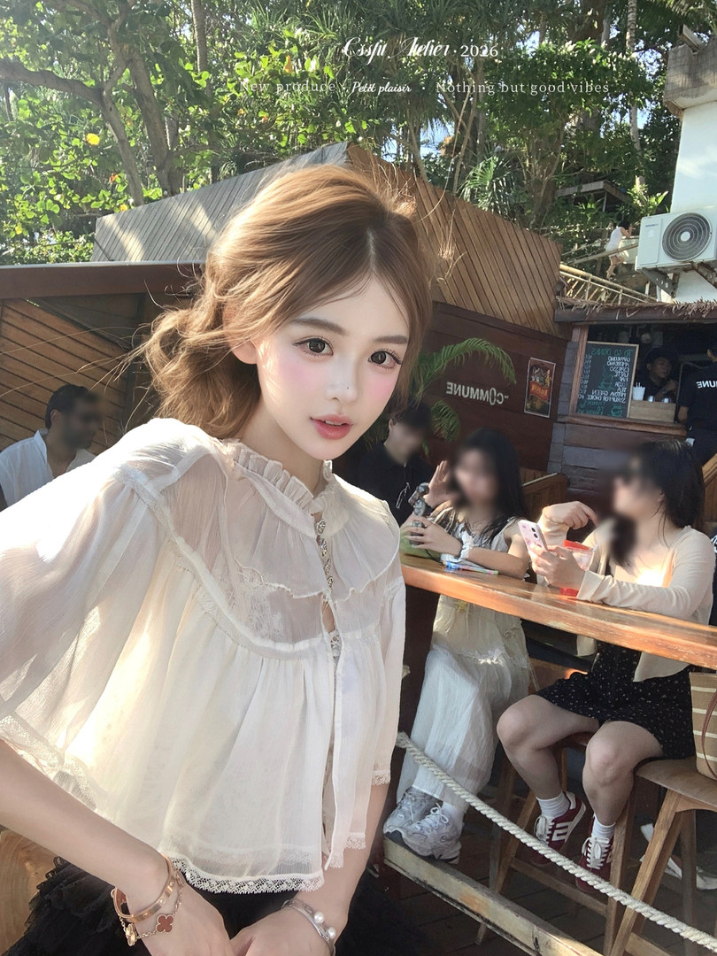Woman wearing a sheer white ruffled blouse outdoors