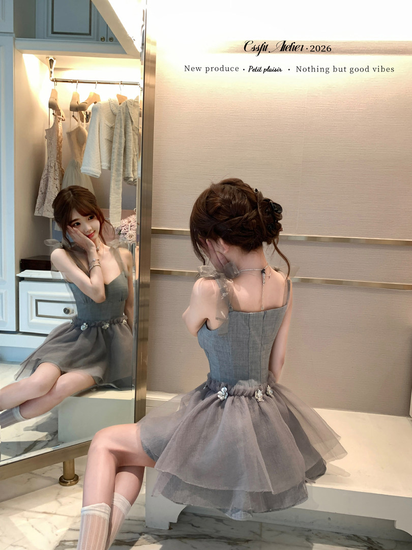 Grey tulle dress worn by a model in a boutique fitting area