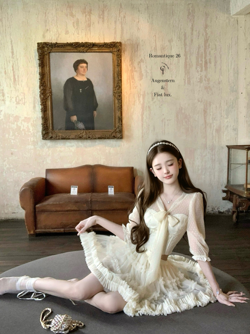 Cream ruffled dress worn by a woman in a vintage-style room