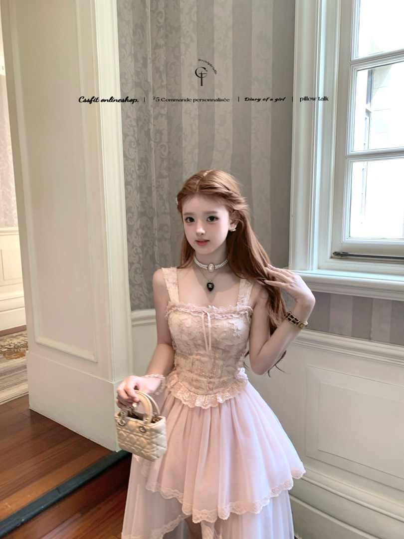 Pink lace corset dress worn by a model holding a small quilted handbag
