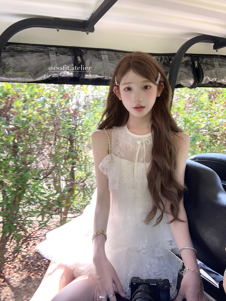 White lace sleeveless dress worn by a model outdoors