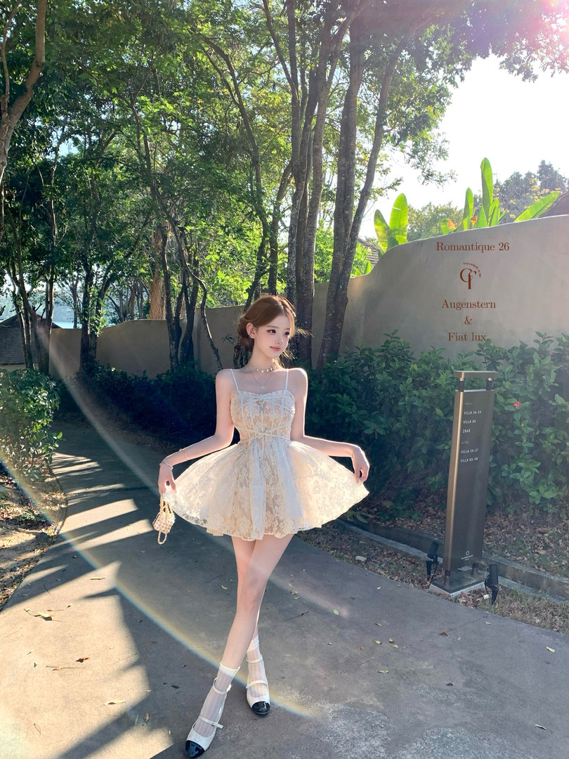 Model wearing a cream lace mini dress outdoors