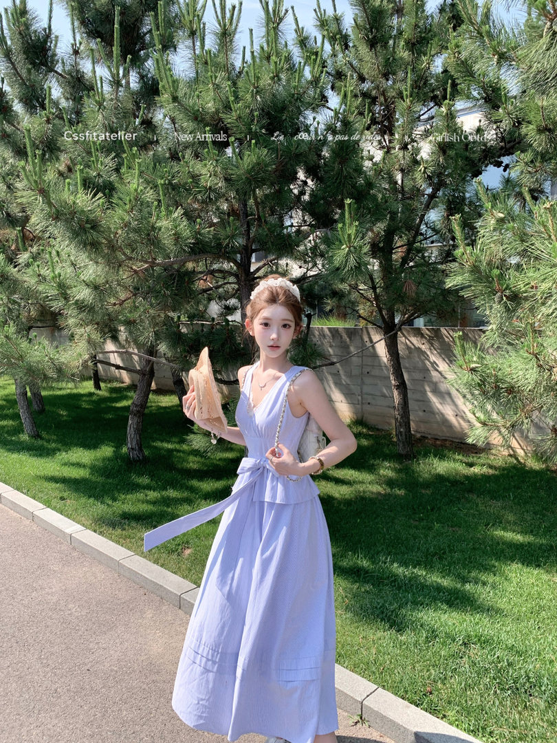 Woman wearing a light blue sleeveless midi dress outdoors