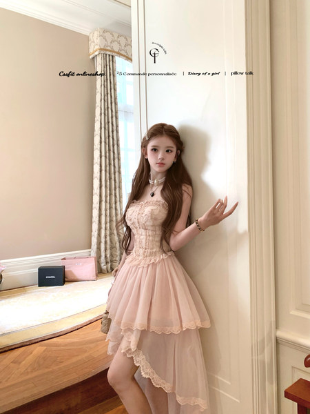 Pink lace dress worn by a model indoors