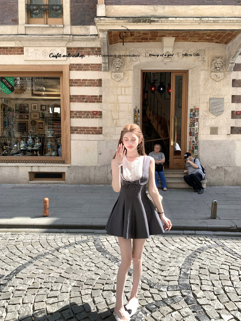 Sleeveless dark gray fit-and-flare dress worn outdoors on a city street