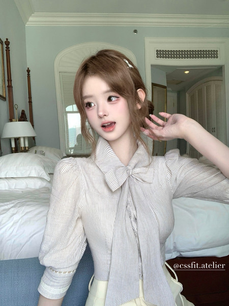 Woman wearing a light striped bow-tie blouse