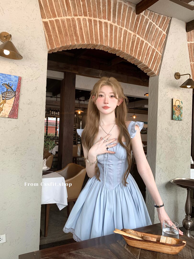Light blue sleeveless dress worn by a model in a restaurant