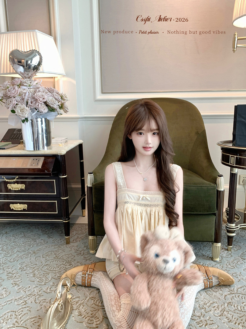 Cream lace-trim sleeveless dress worn by a model indoors