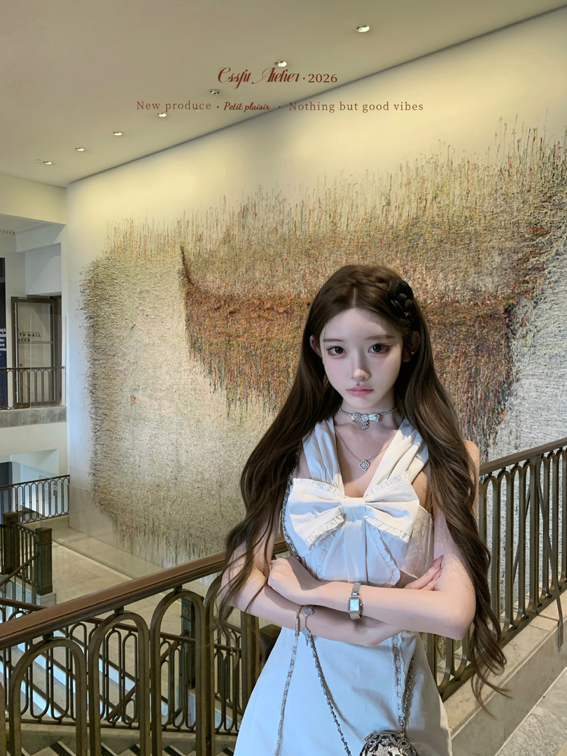 Woman modeling a white sleeveless dress indoors
