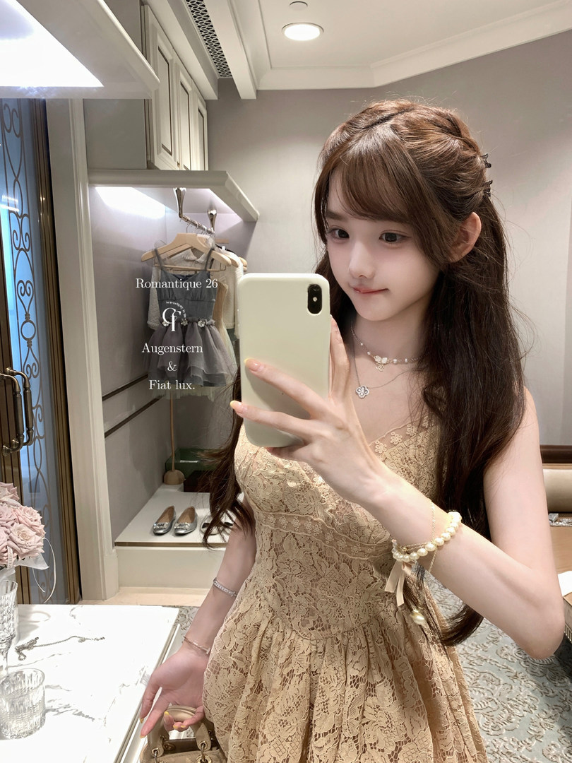 Woman wearing a beige lace dress in a mirror selfie