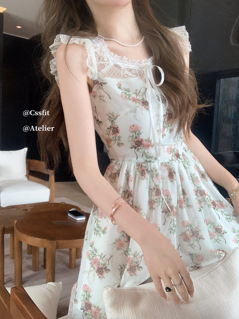 Woman wearing a white floral lace-trim dress with bow detail