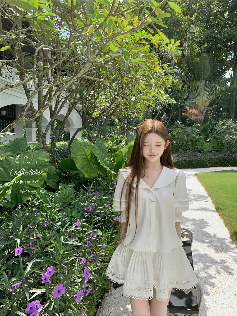 Young woman wearing a white ruffled dress in a tropical garden