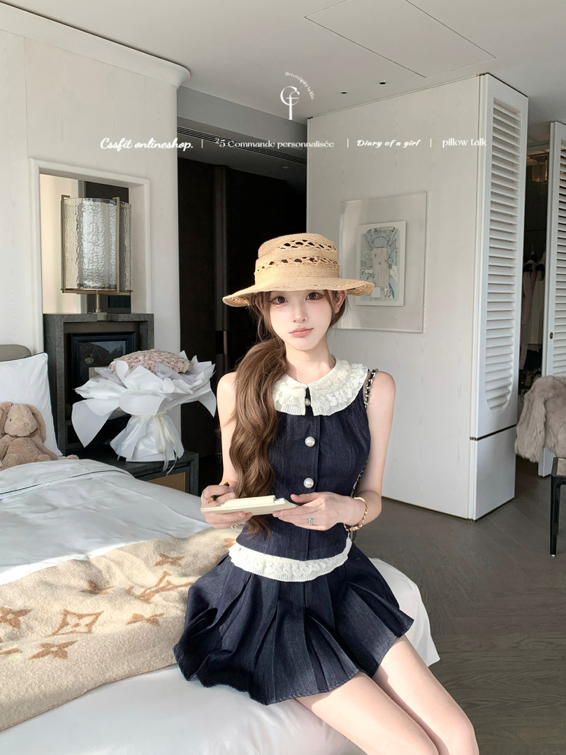 Woman wearing a navy denim two-piece outfit with a straw hat