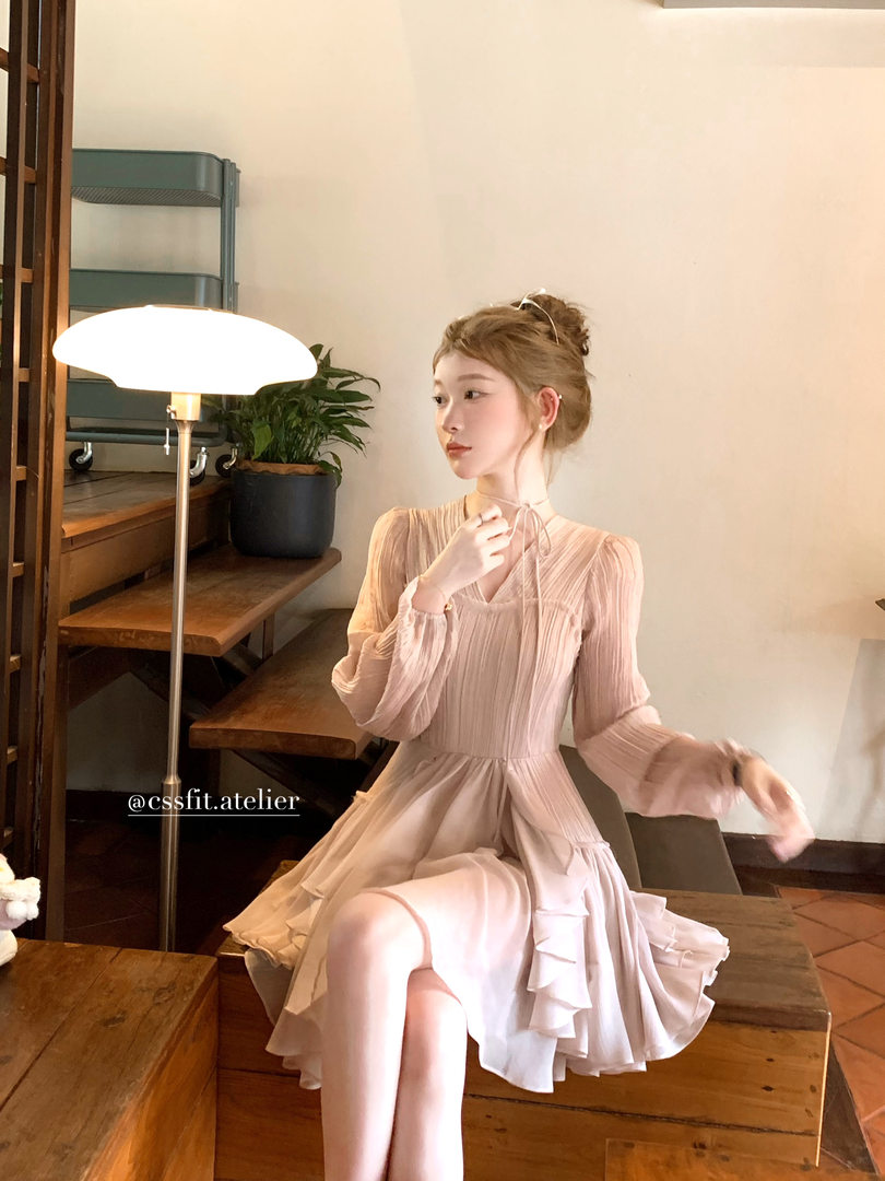 Woman wearing a light pink pleated long-sleeve dress