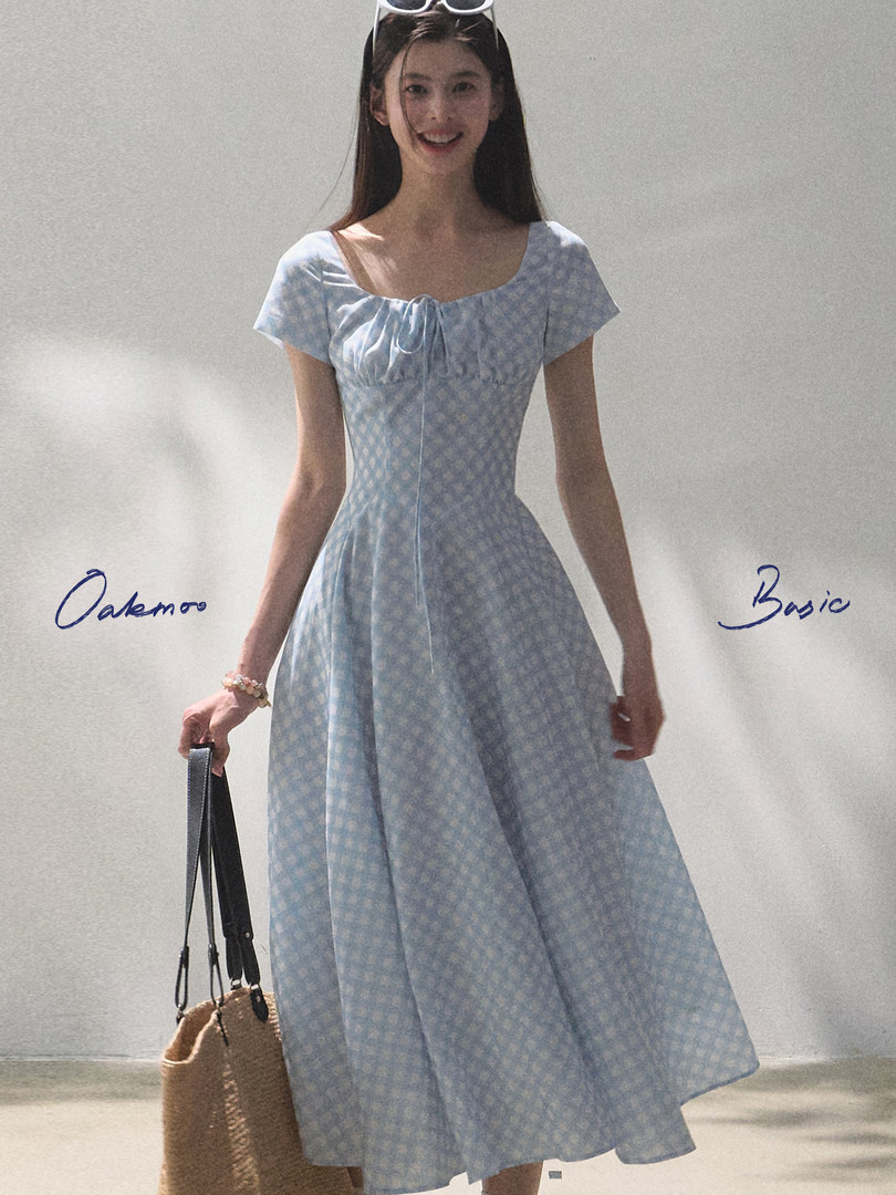 Model wearing a light blue patterned midi dress with short sleeves
