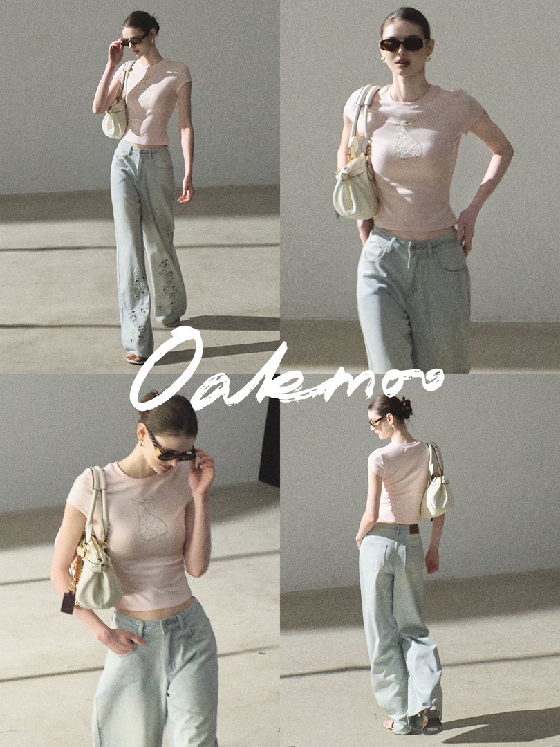 Fashion model wearing a fitted pink T-shirt with light blue wide-leg jeans and a small shoulder bag