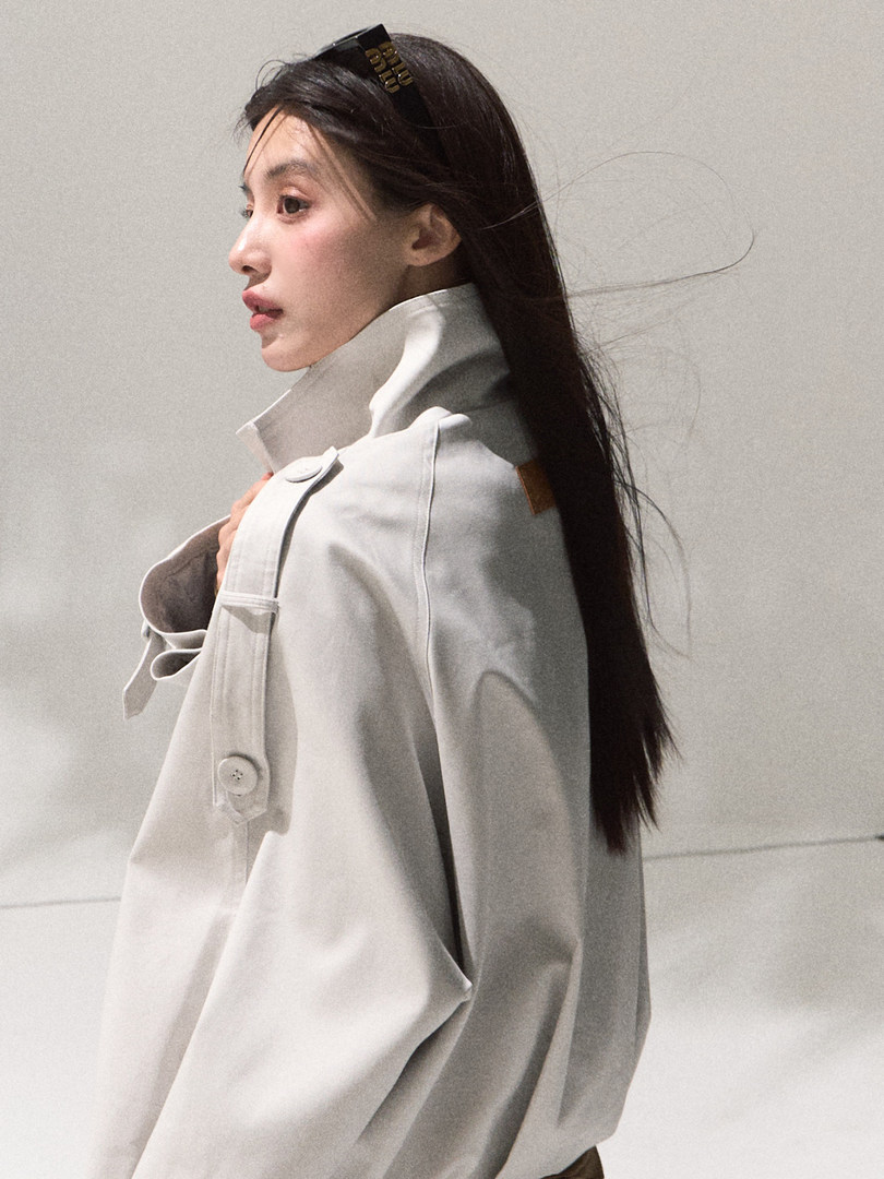 Woman wearing a white oversized coat with a high collar