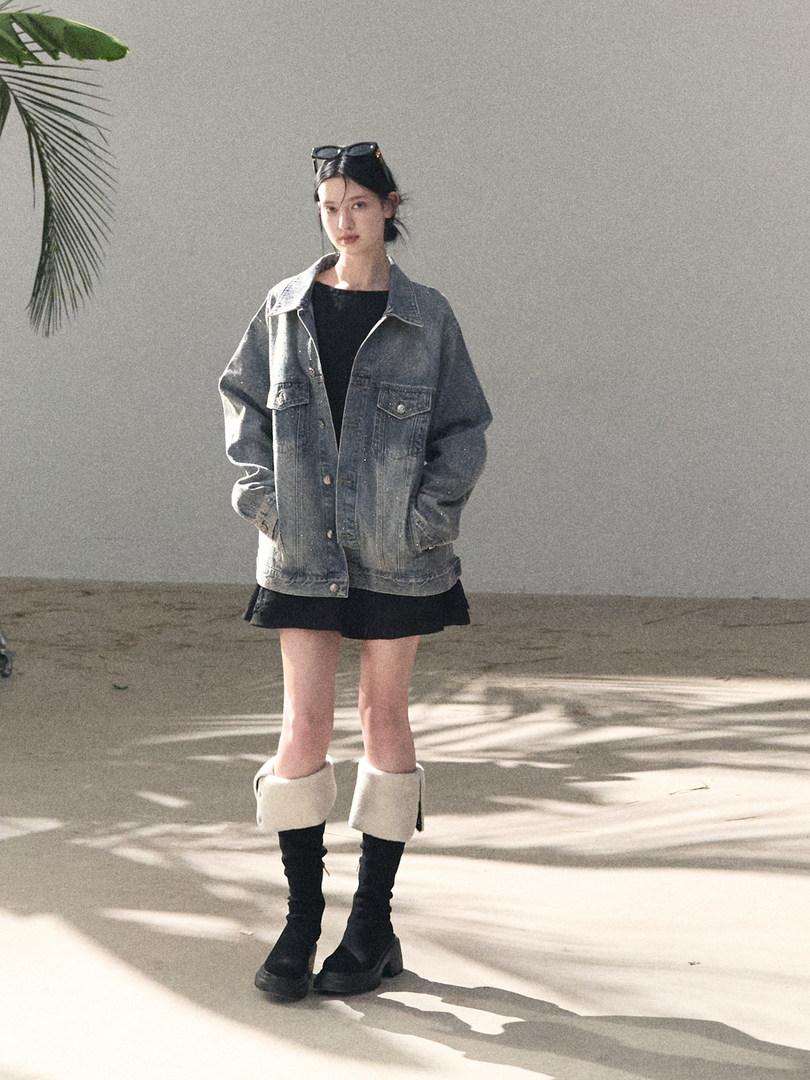 Model wearing a gray denim jacket with a black outfit and boots