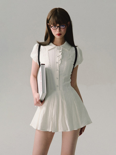 White short-sleeve pleated dress worn by a model
