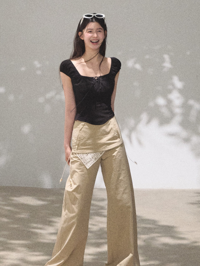 Woman wearing a black sleeveless top and beige wide-leg pants