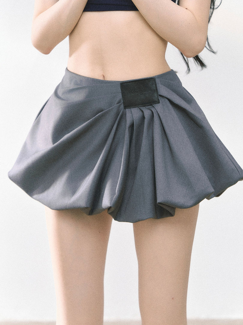 Gray pleated mini skirt worn by a model
