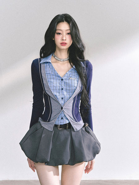Model wearing a blue plaid shirt with a gray and navy cardigan and a flared mini skirt
