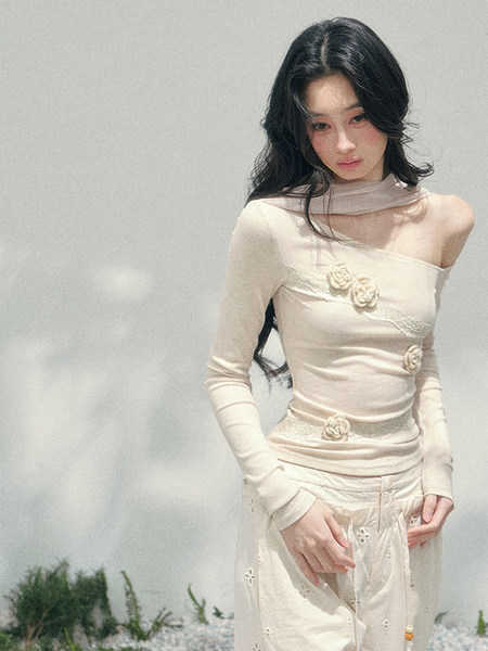 Model wearing a cream off-shoulder embellished two-piece outfit
