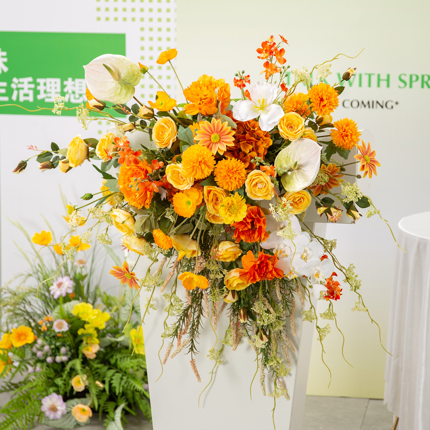 橙色系讲台花彷真花开业庆典商务会议演讲台花艺装饰遮挡桌花挂花