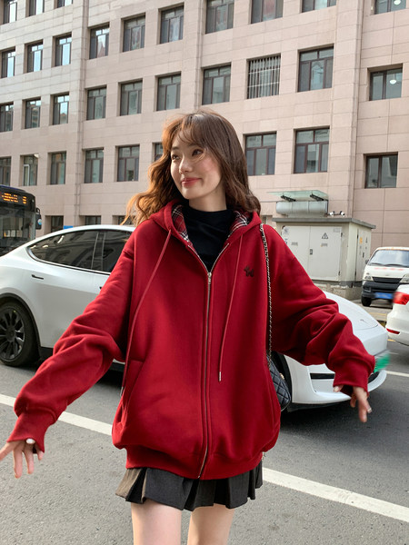 Woman wearing a red oversized zip-up hoodie outdoors