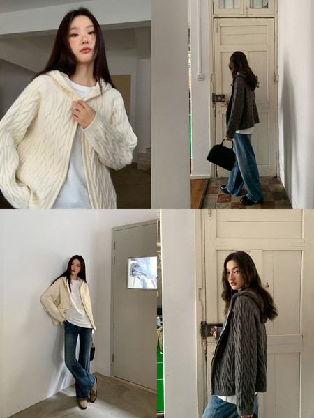 Model wearing a cable-knit hooded cardigan in cream and charcoal