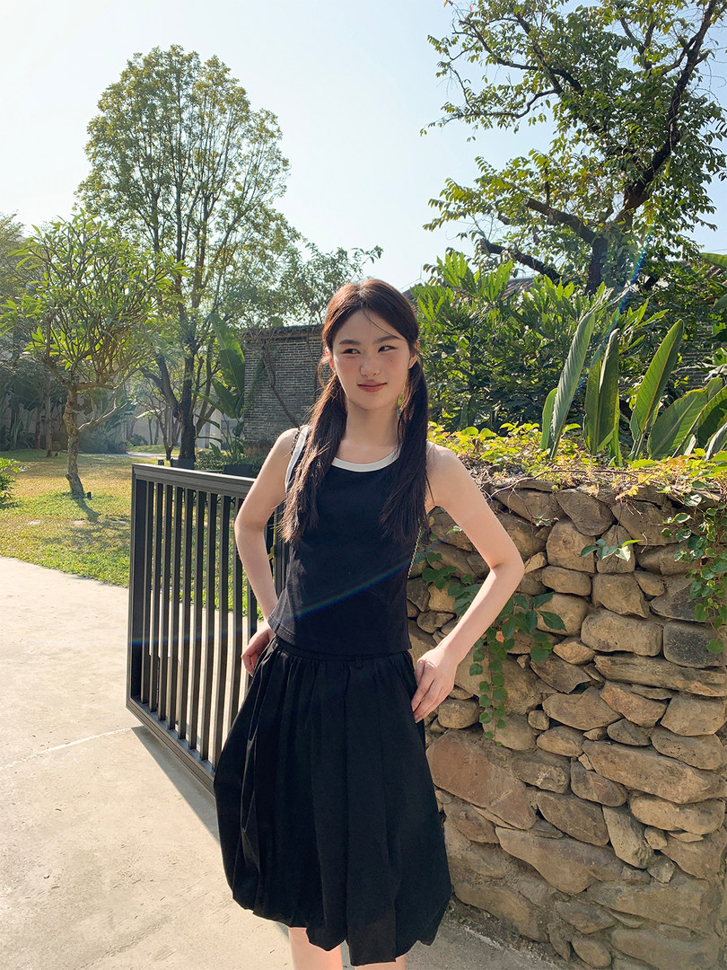 Black sleeveless dress worn by a model outdoors