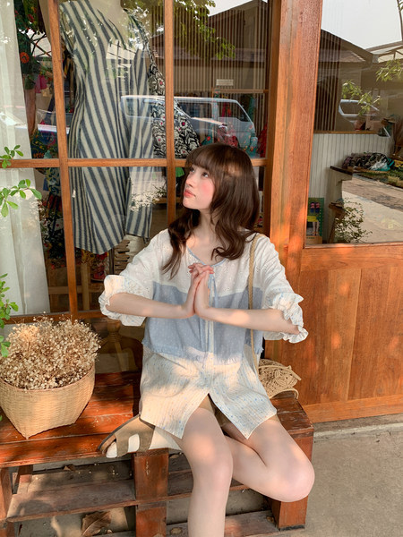 Woman wearing a light blue and white casual summer romper