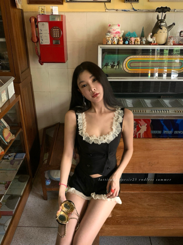 Woman wearing a black sleeveless ruffled two-piece outfit