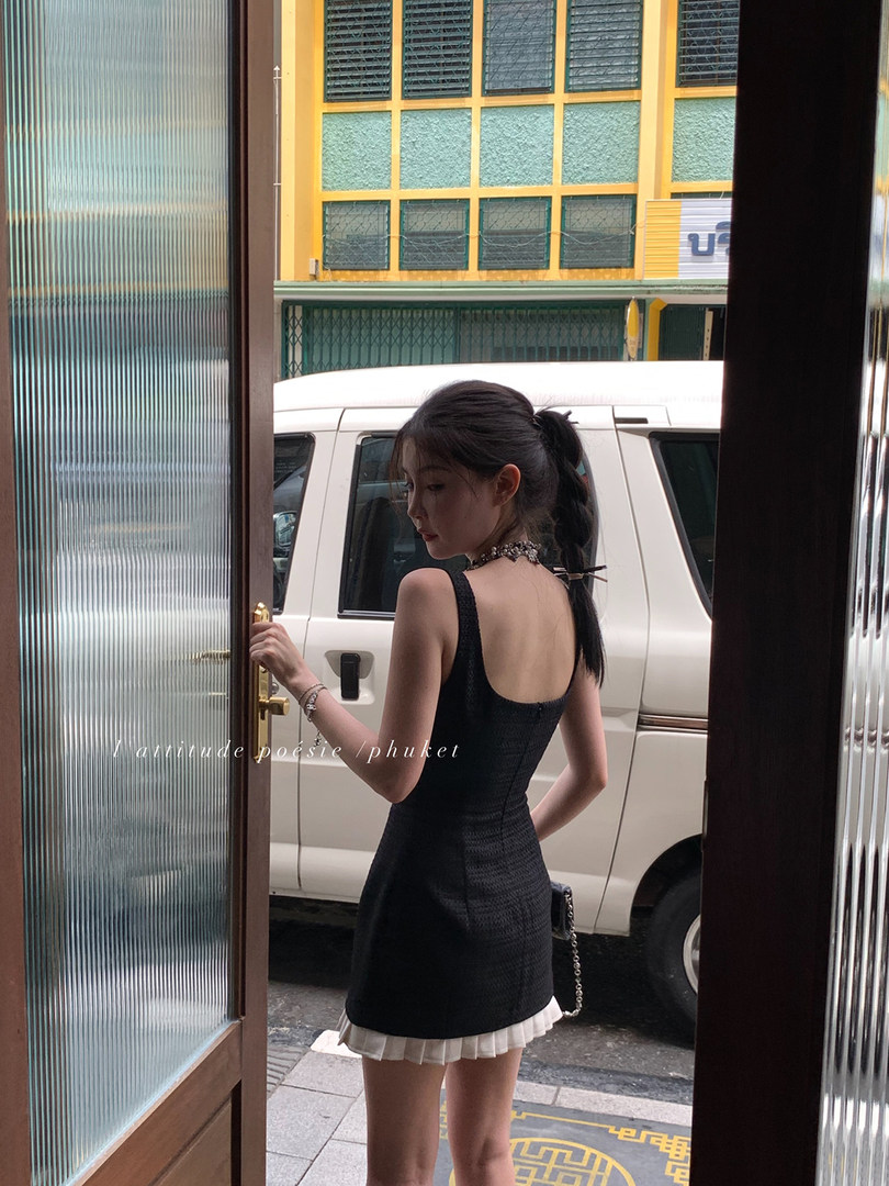 Black sleeveless mini dress worn by a model outdoors
