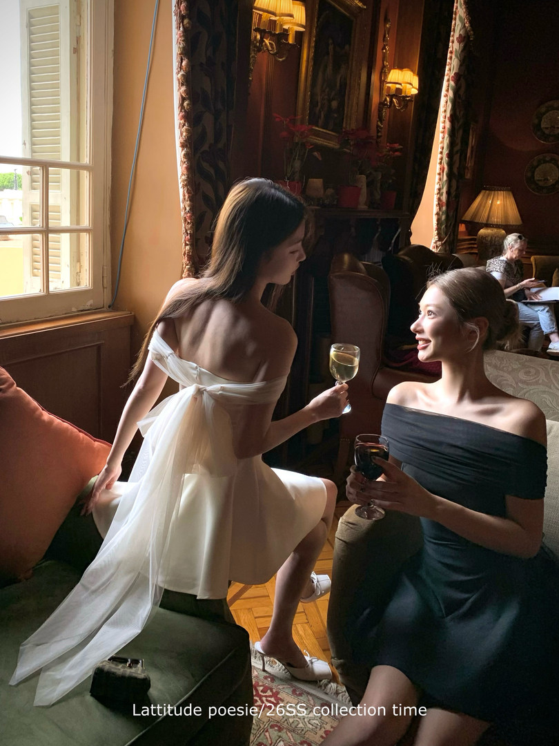 Women wearing off-shoulder dresses at an indoor social event