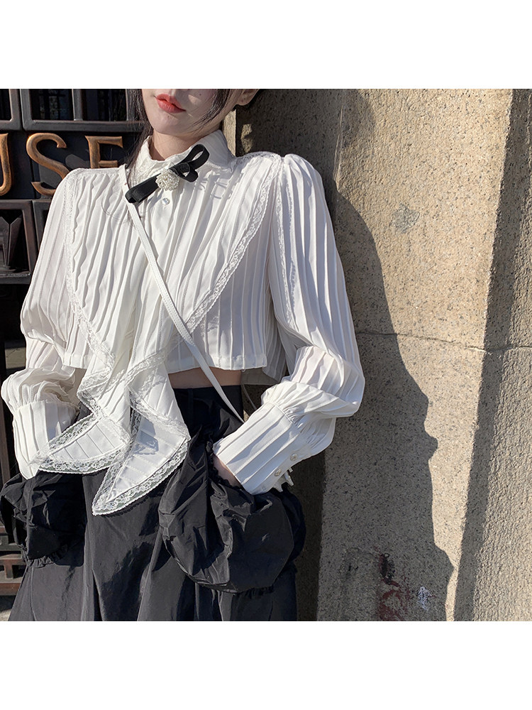 White ruffled long-sleeve blouse worn by a model