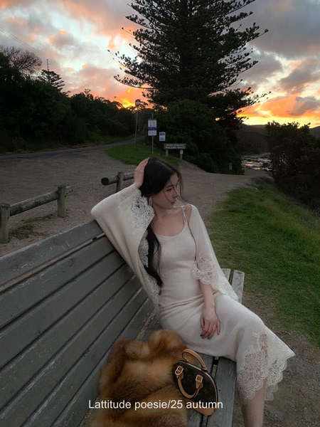 Cream lace-trim long dress worn by a model outdoors at sunset