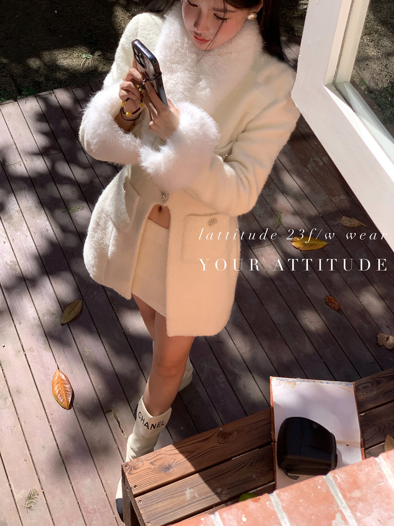 Woman modeling a white faux-fur coat and matching winter outfit